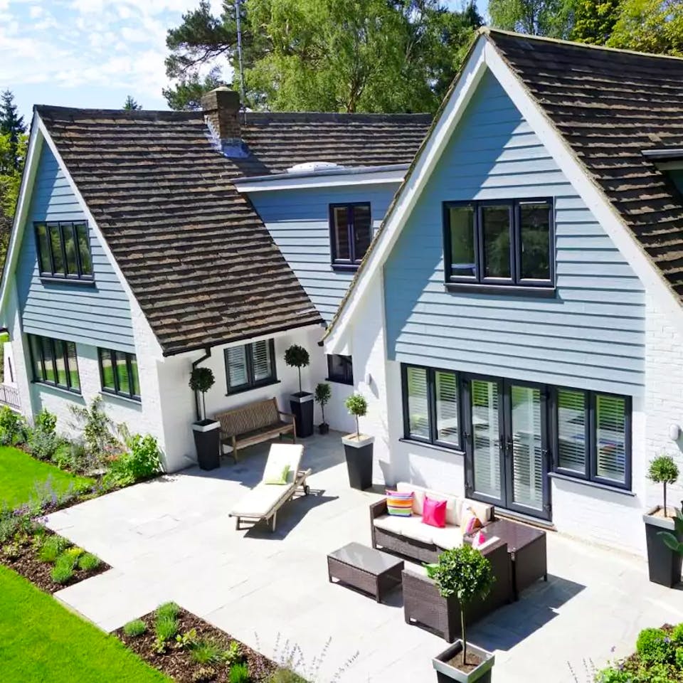 Blaues Holz-Doppelhaus mit Satteldach und Terrasse