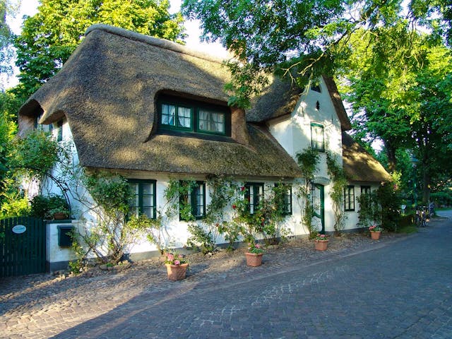 Reetdachhaus mit typischem Krüppelwalmdach, Gauben und Zwerchgiebel