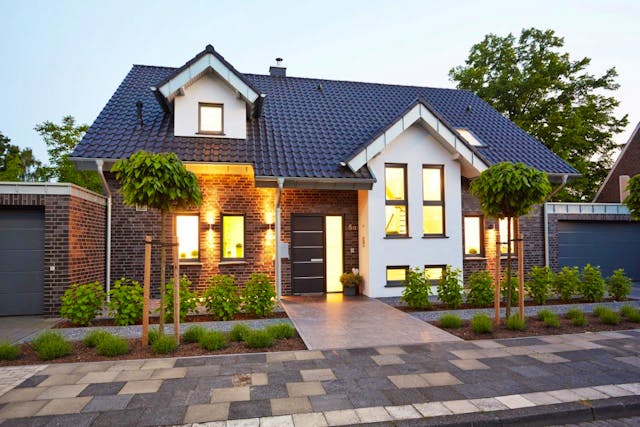 Frontansicht des Fertighauses Vahrenheide mit Dachgaube, Zwerchhaus über schmalem Standerker & kleinem Schleppdach über dem Eingangsbereich von GUSSEK HAUS