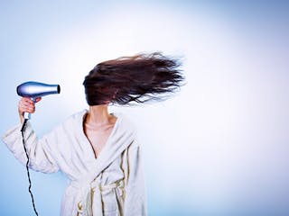 Frau föhnt sich Haare Frau föhnt sich Haare