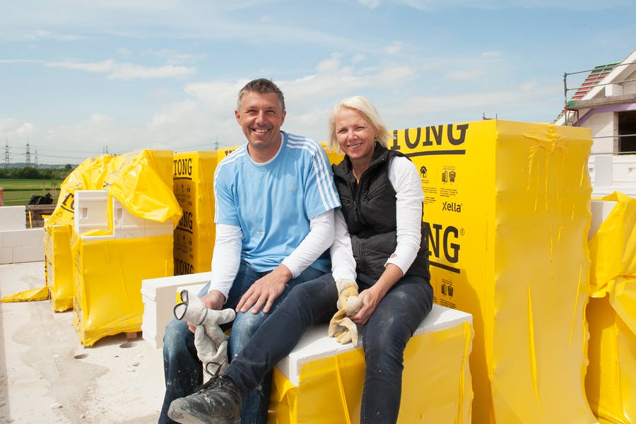 Das Bauherrenpaar Sabine und Gerd Steinkamp sitzt auf seiner Baustelle auf den Ytong Bausätzen